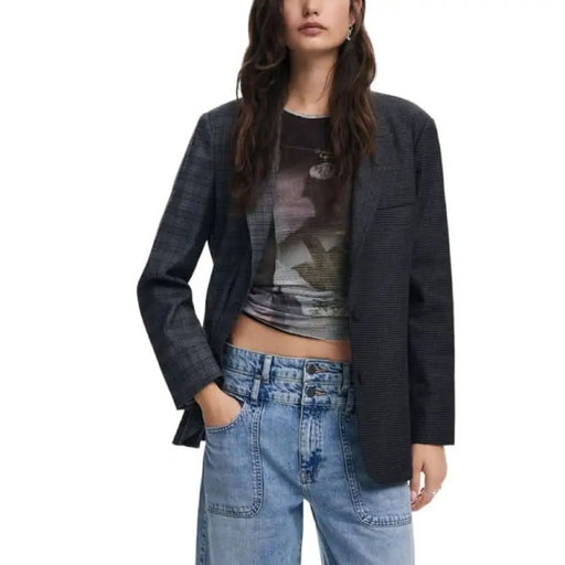 Woman in dark blazer over graphic t-shirt with blue jeans by Desigual