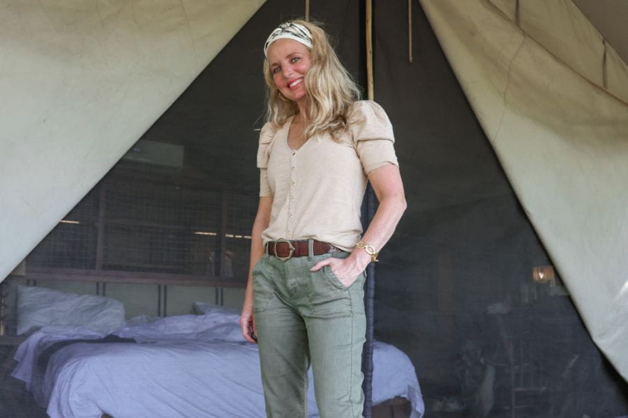 Woman in white top and green pants showcasing an elegant holiday outfit.