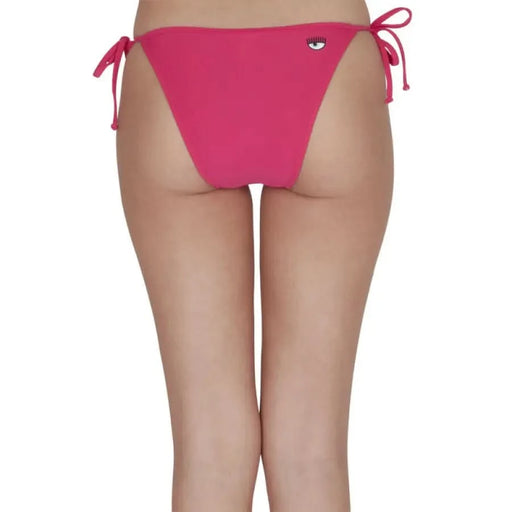 Woman in Chiara Ferragni pink bikini bottom, beachwear by Chiara Ferragni. Urban chic style