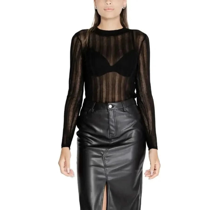 Woman in sheer black long-sleeved top and leather skirt from Vila Clothes Knitwear