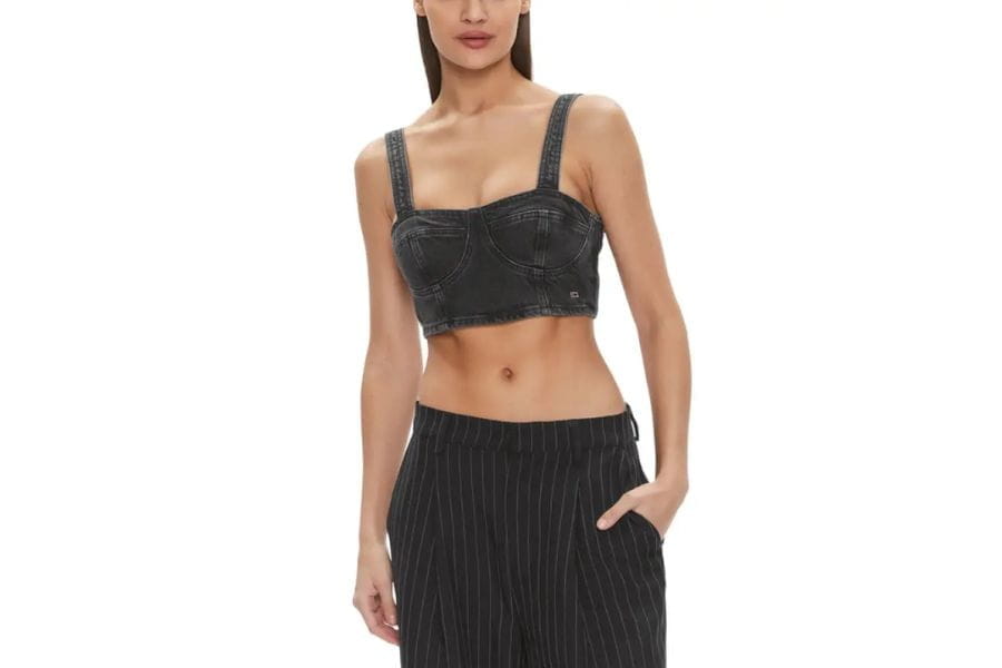 Woman in a black crop top and high-waisted pants showcasing summer outfit ideas to shop.