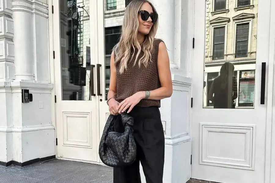 Woman in sunglasses and brown top showcasing summer outfit ideas while holding handbag.