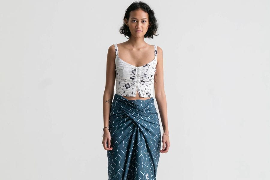 Woman in floral crop top and blue wrap skirt showcasing summer outfit ideas to shop.