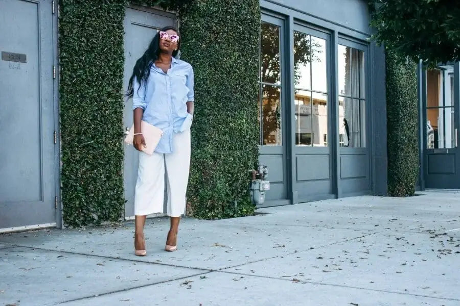 Woman in white oversized shirt with pink flower in her hair for stylish outfit idea.