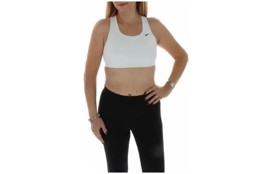 Woman in white sports bra and black leggings for a stylish first date outfit.