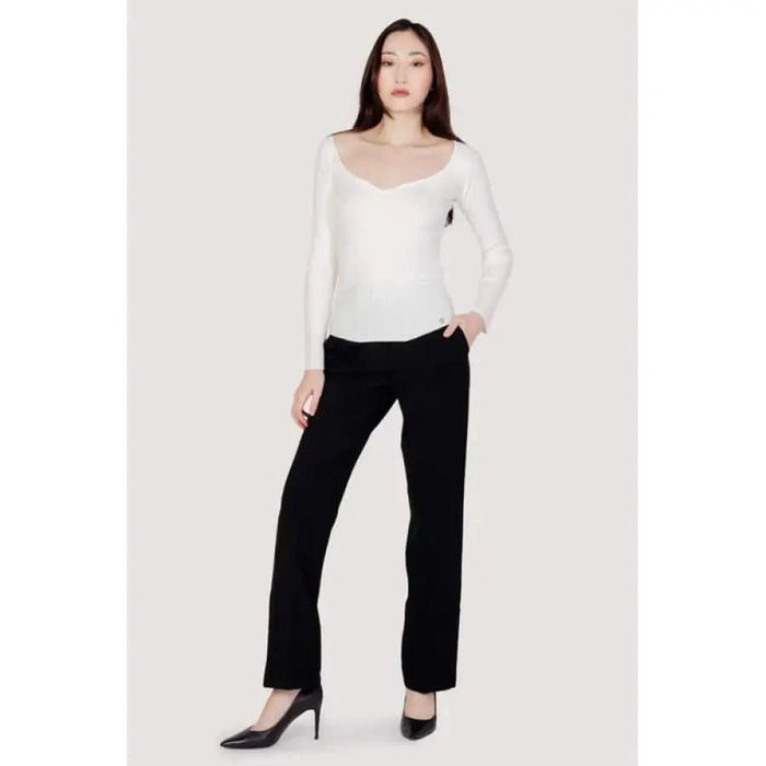 Woman in Guess white long-sleeved top, black trousers, and high heels - Guess Women Knitwear