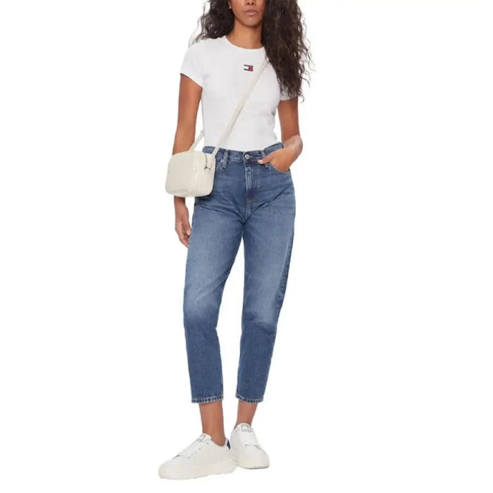 Woman in Tommy Hilfiger White T-Shirt, Blue Jeans, Sneakers, & Shoulder Bag