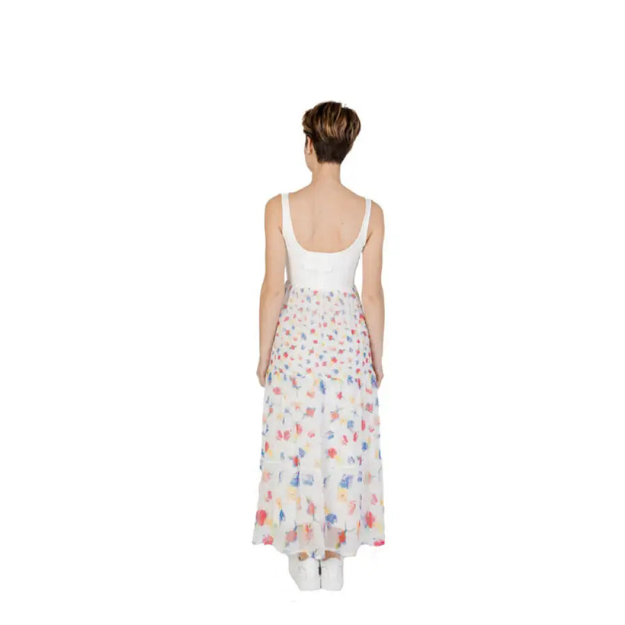 Woman in a Desigual dress wearing a white tank top and floral-patterned long skirt, back view