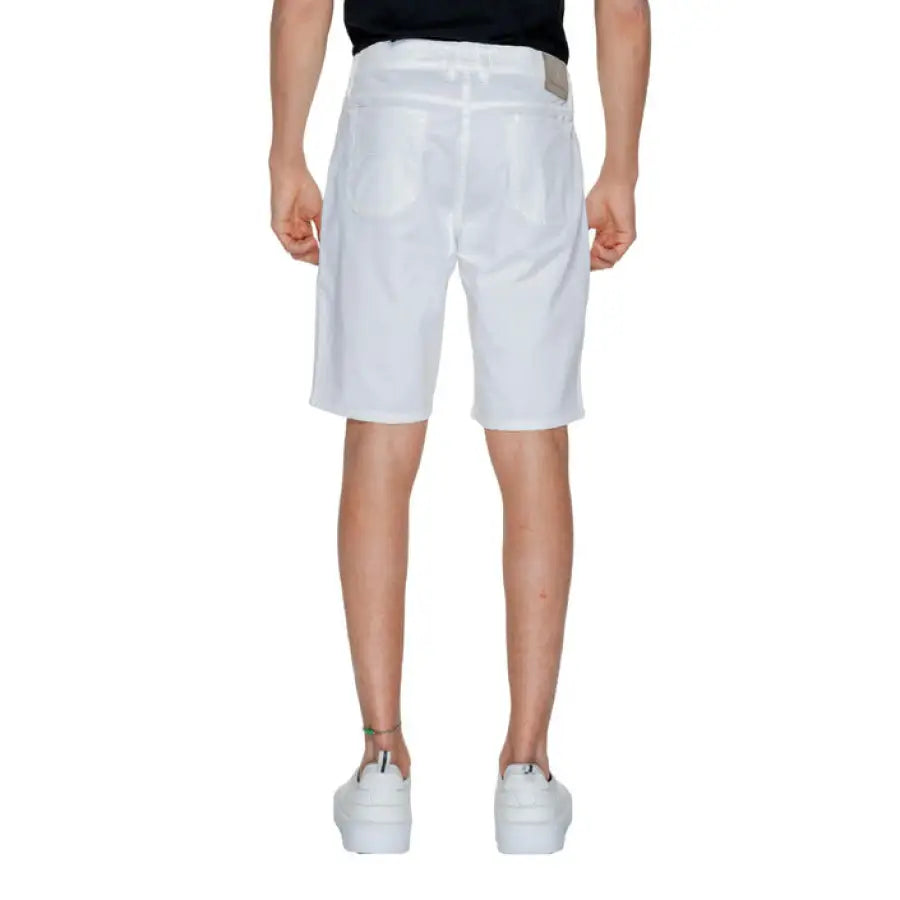 Young boy wearing white Jeckerson Men Shorts and a black T-shirt