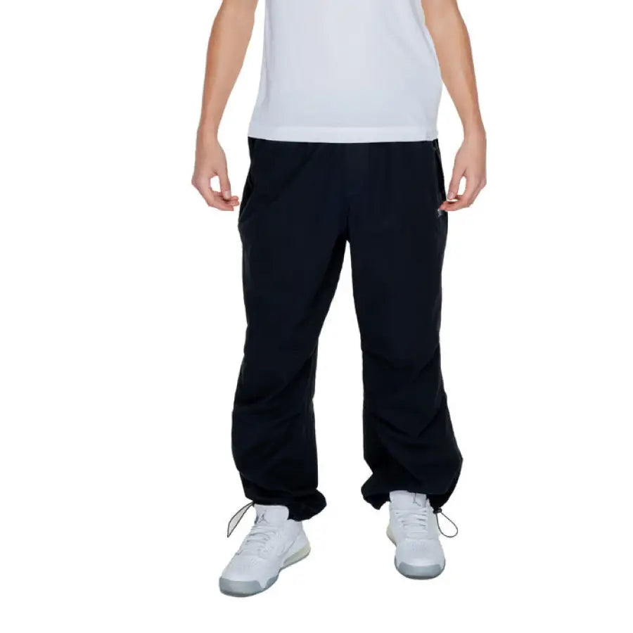 Young boy in Karl Kani Men Trousers, urban style clothing, white shirt, black pants