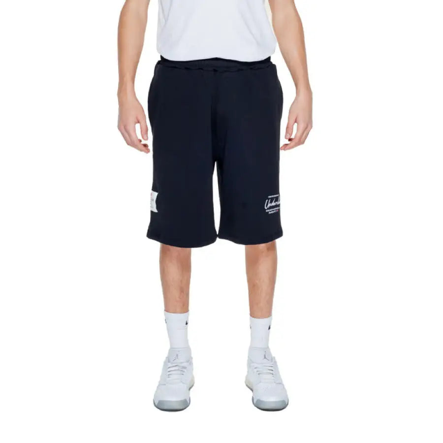 Young man wearing Underclub Men Shorts with a white t-shirt and black shorts
